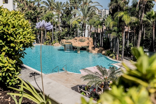 Een buitenzwembad, parasols voor strand/zwembad