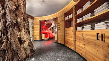 Relax in a serene spa room with a bathtub, wooden cabinet, and natural elements.