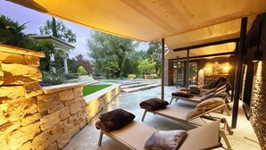 An outdoor lounge area with stone walls and a covered patio. - Hotel-Restaurant Rebstock (Durbach)