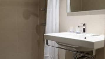 A bathroom with a shower, a sink, and a mirror.