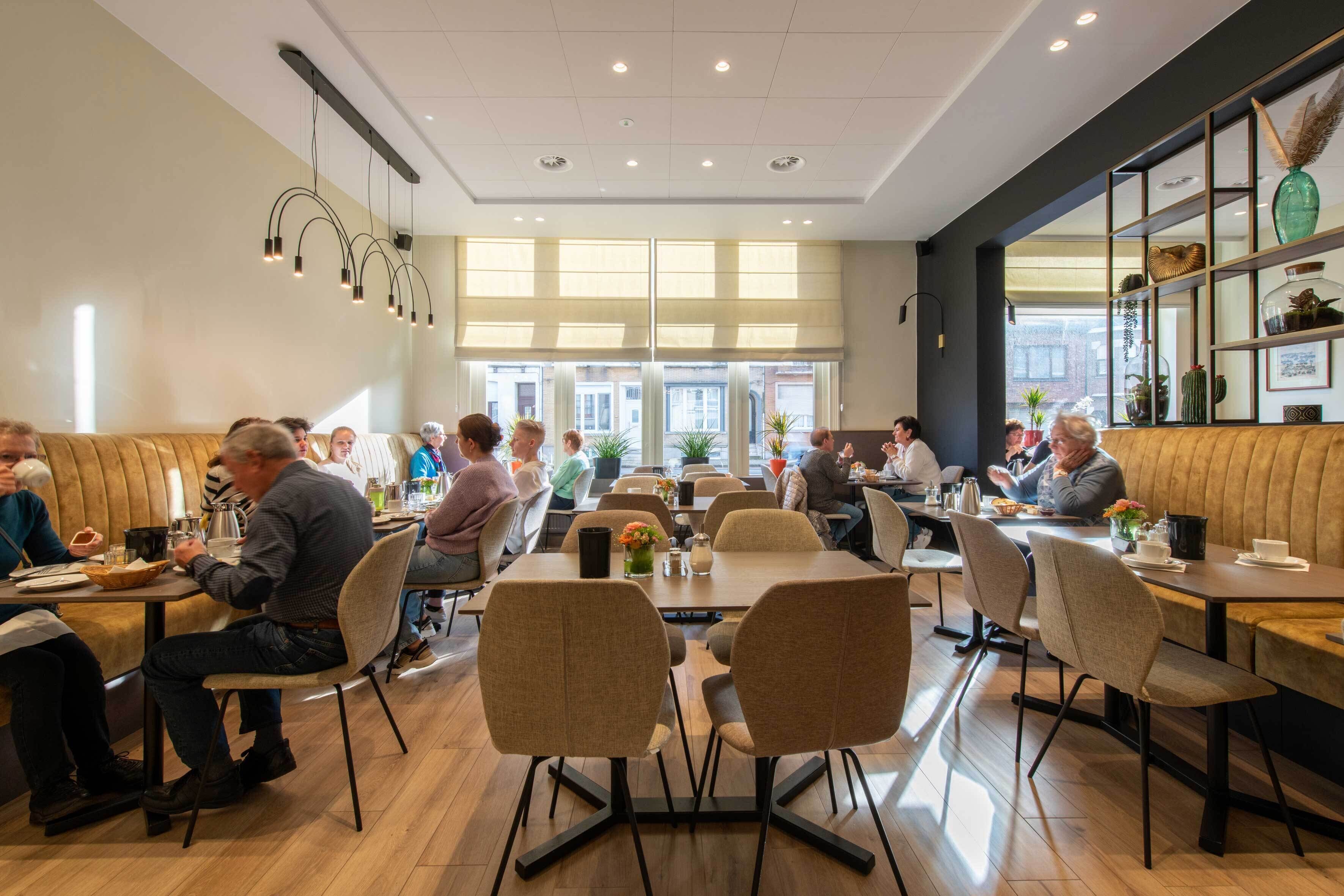 Un vaste espace dédié à la salle à manger, avec de nombreuses tables et chaises, de grandes fenêtres et un aménagement intérieur moderne.