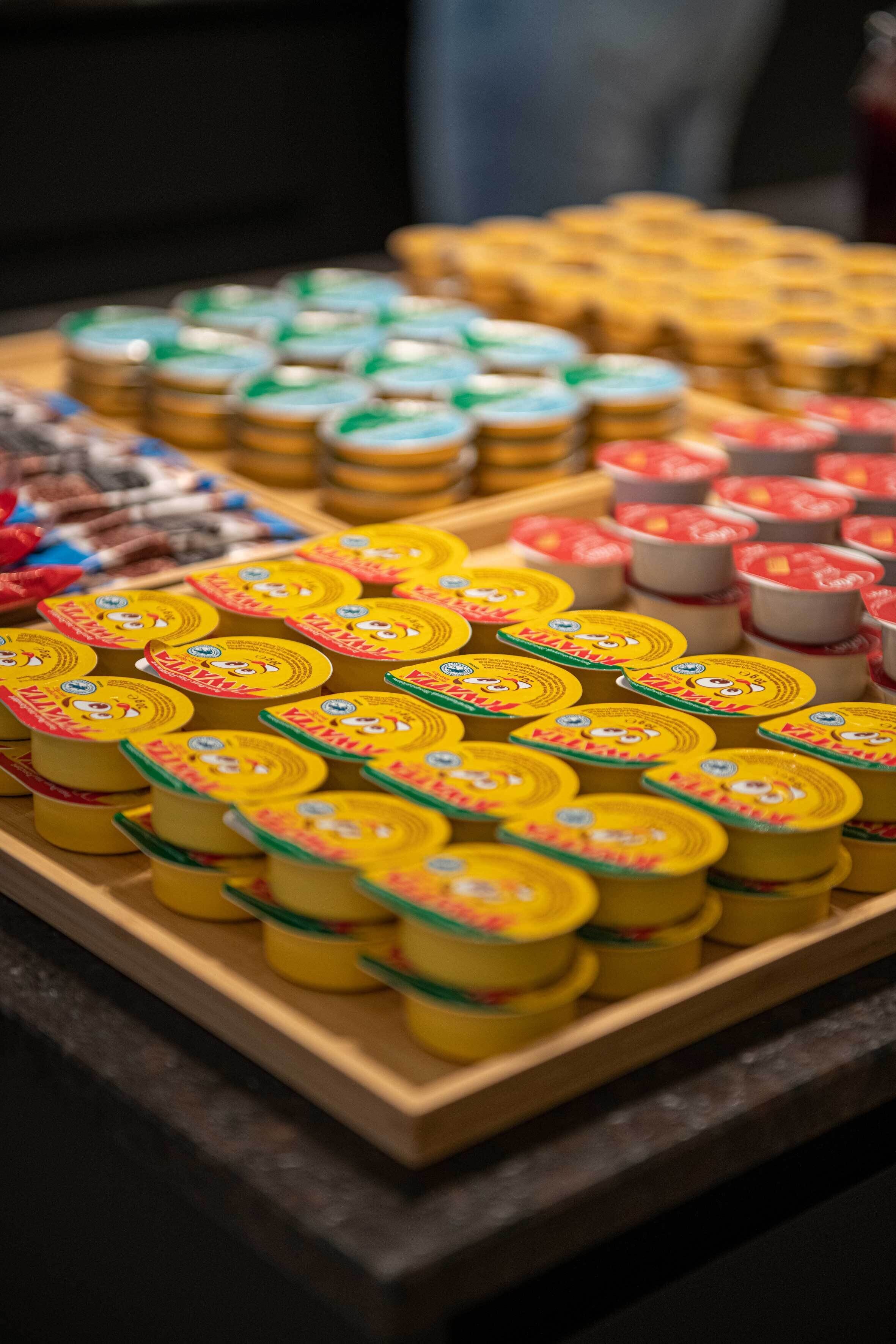 A display of various packaged goods, likely dairy products, arranged on wooden shelves.