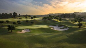 A golf course with sand bunkers, trees, and rolling terrain. - Las Colinas Golf & Country Club (Orihuela)