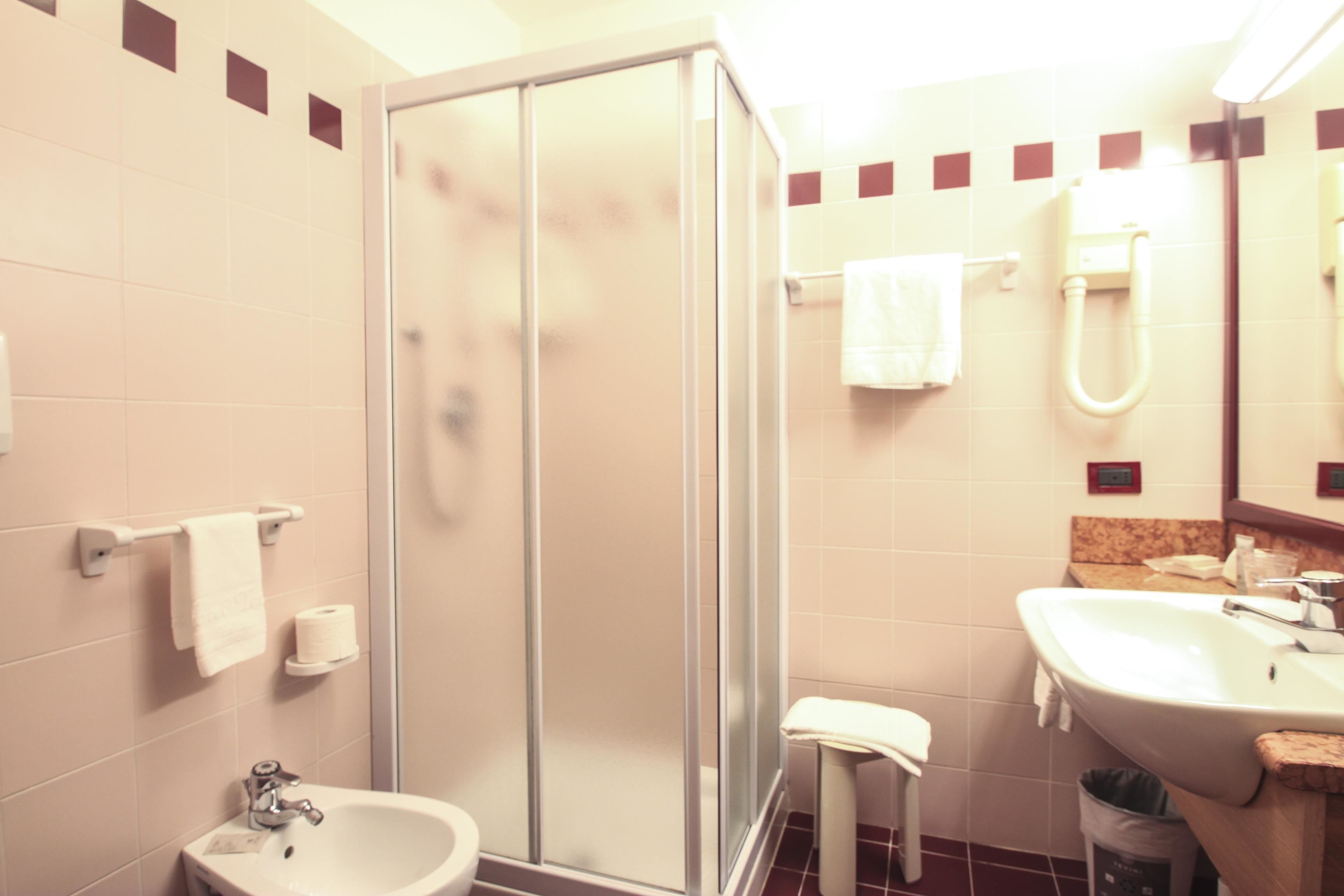 Ein Badezimmer mit Duschkabine, Waschbecken und Toilette.