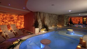 A spa area with a hot tub, lounge chairs, and decorative plants.