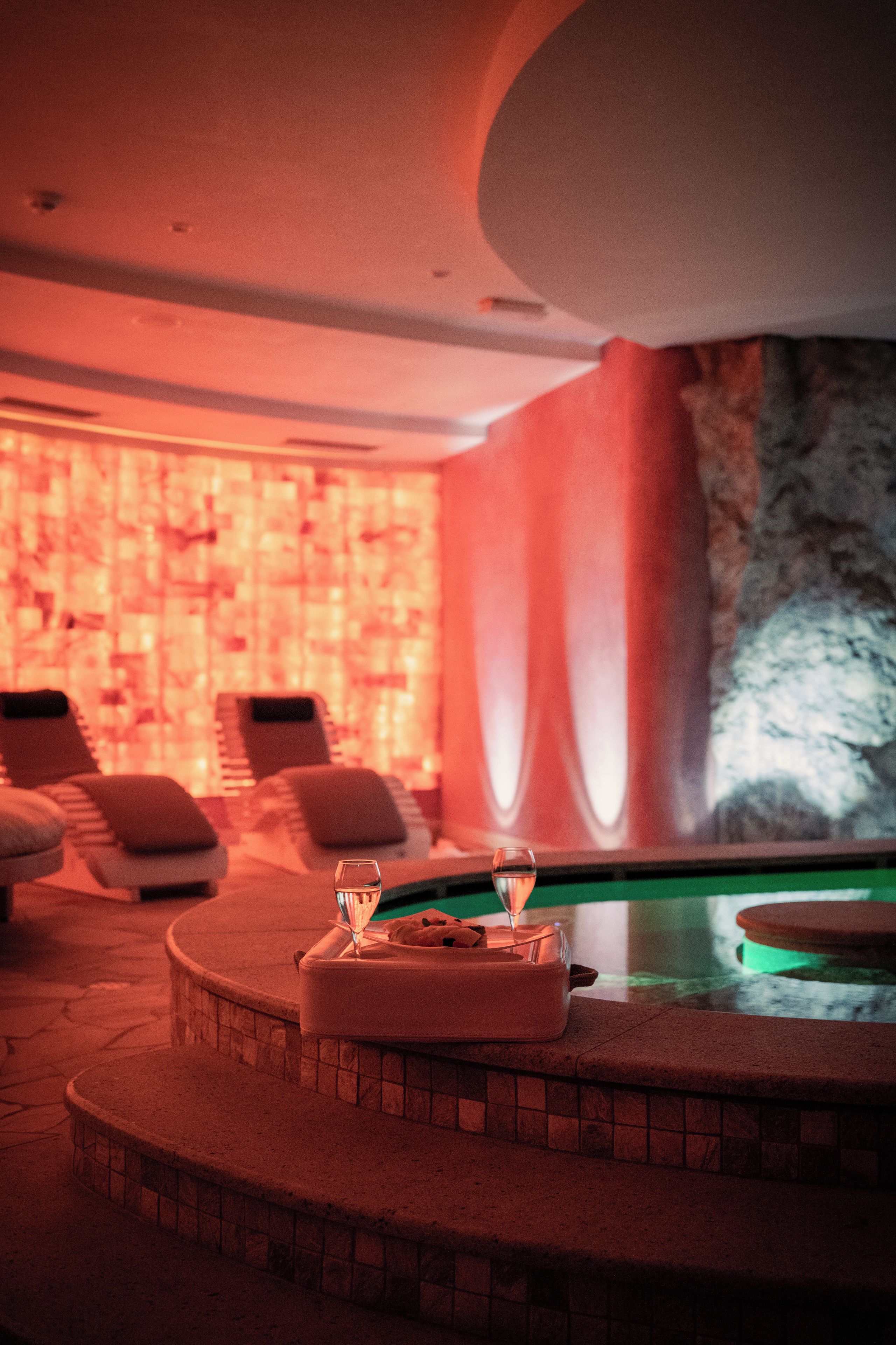 A spa area with a pool, lounge chairs, and a massage table.