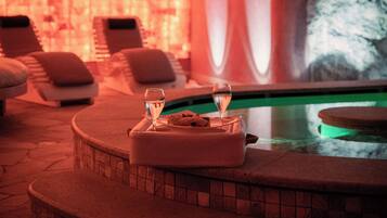A spa area with a pool, lounge chairs, and a massage table.