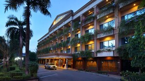 A hotel with multiple balconies, a well-lit entrance, and a car parked in front. - Goodway Hotel Batam (Batam)