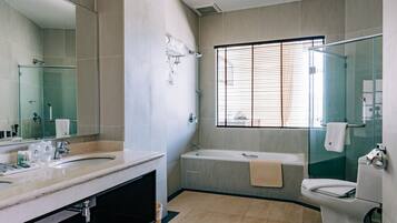 Een moderne badkamer met een wastafel met dubbele wastafel, een badkuip en een douche met glazen wand.