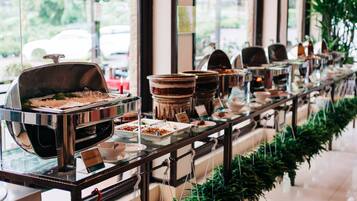 A buffet setup with various food stations and a coffee machine.