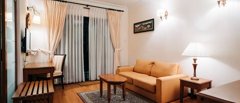 A living room with a sofa, a wooden coffee table, a chair, a lamp, and a rug.