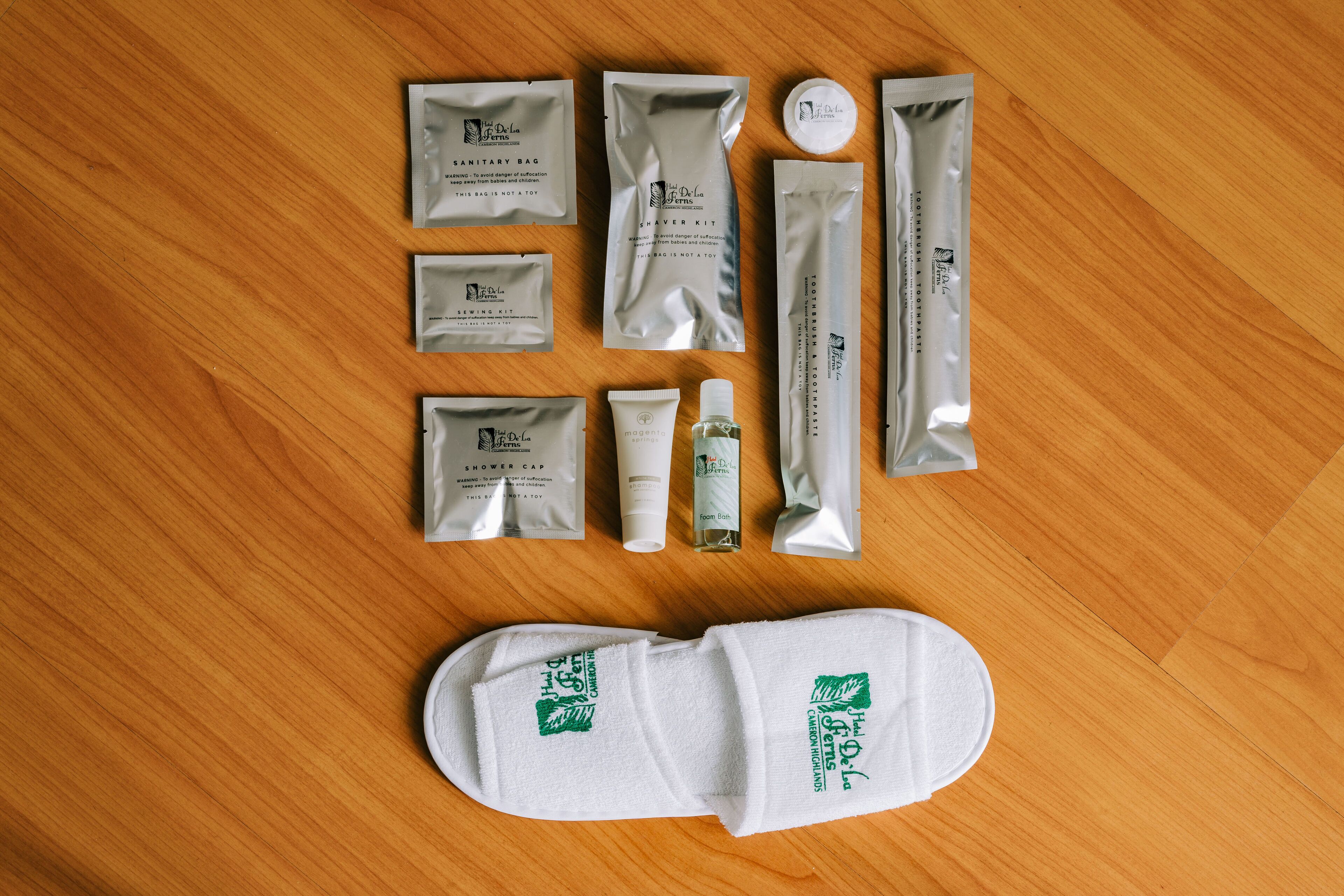 A neatly arranged set of toiletries and a white bath mat on a wooden floor.