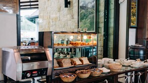 A buffet setup with a toaster oven, bread, and various dishes. - Hotel De'La Ferns, Cameron Highlands (Tanah Rata)
