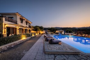 Un espace aménagé au bord de la piscine, avec des chaises longues et une piscine.
