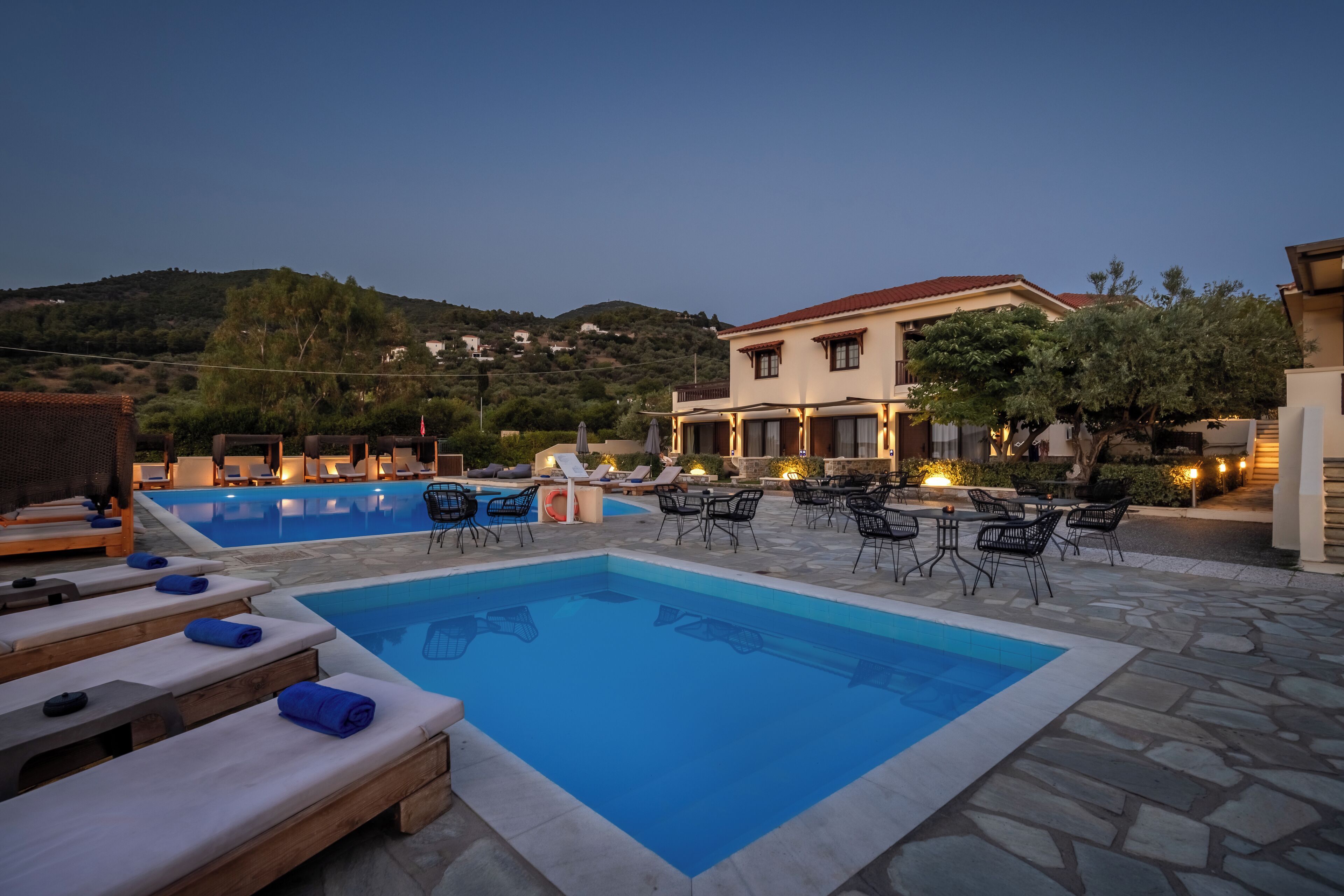 A pool area with lounge chairs and a stone patio.