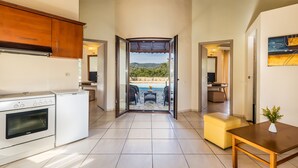Cozinha com vista para um pátio, área de refeições e uma pequena mesa com um vaso.