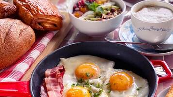 Una colazione con uova, pancetta, pane tostato e una varietà di frutta e verdura.