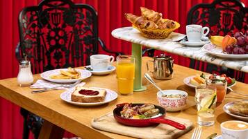 Une table de petit-déjeuner avec divers aliments, une tasse de café et une assiette de fruits.