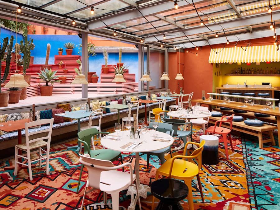 Un restaurante con sillas y mesas coloridas y un interior vibrante.