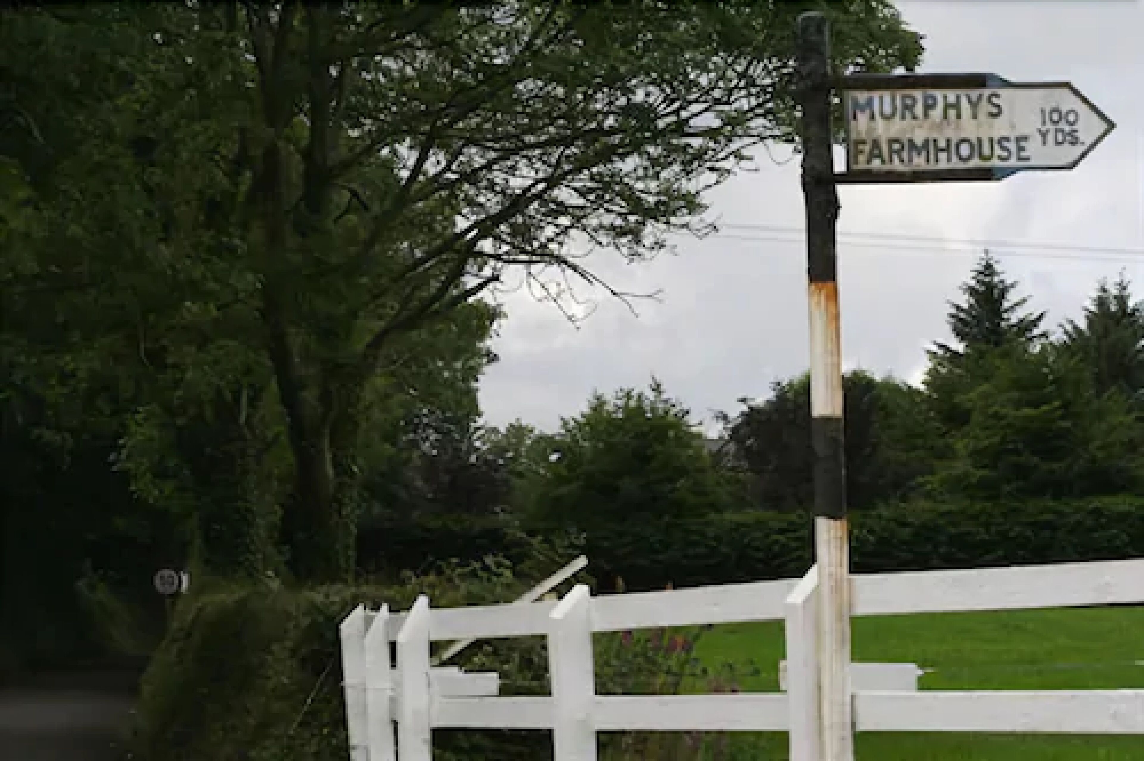 Um sinalizador indicando 'Murphy's Farmhouse' a 100 jardas de distância.