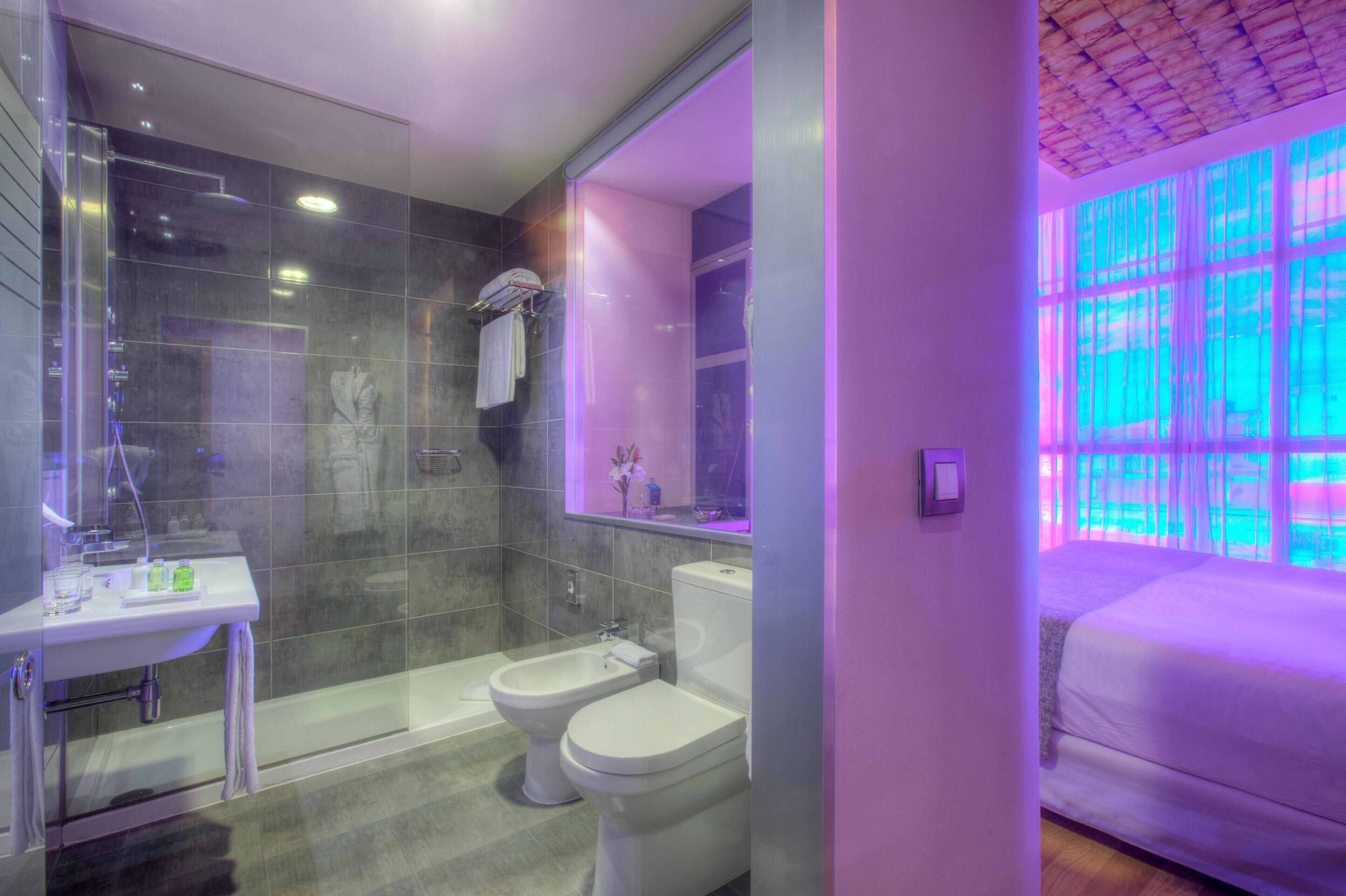 Une salle de bain moderne avec une douche à parois de verre, un lavabo blanc et des toilettes.