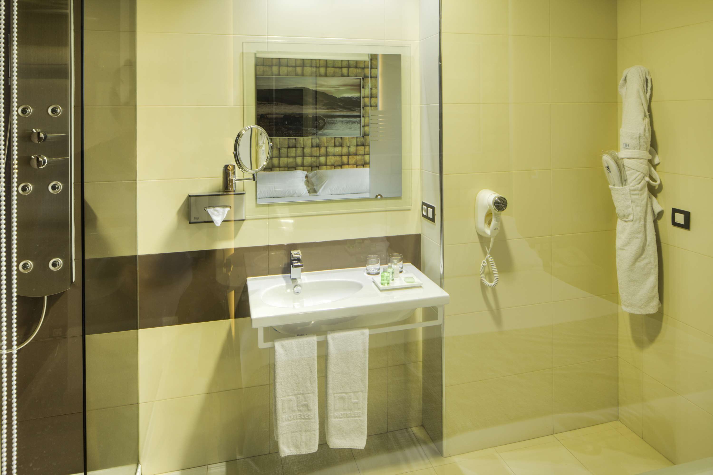 A bathroom with a glass-enclosed shower, a sink with a mirror, and a towel rack.