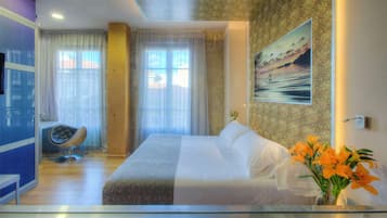 Habitación de hotel con una cama grande, una silla, un escritorio y vistas al exterior.