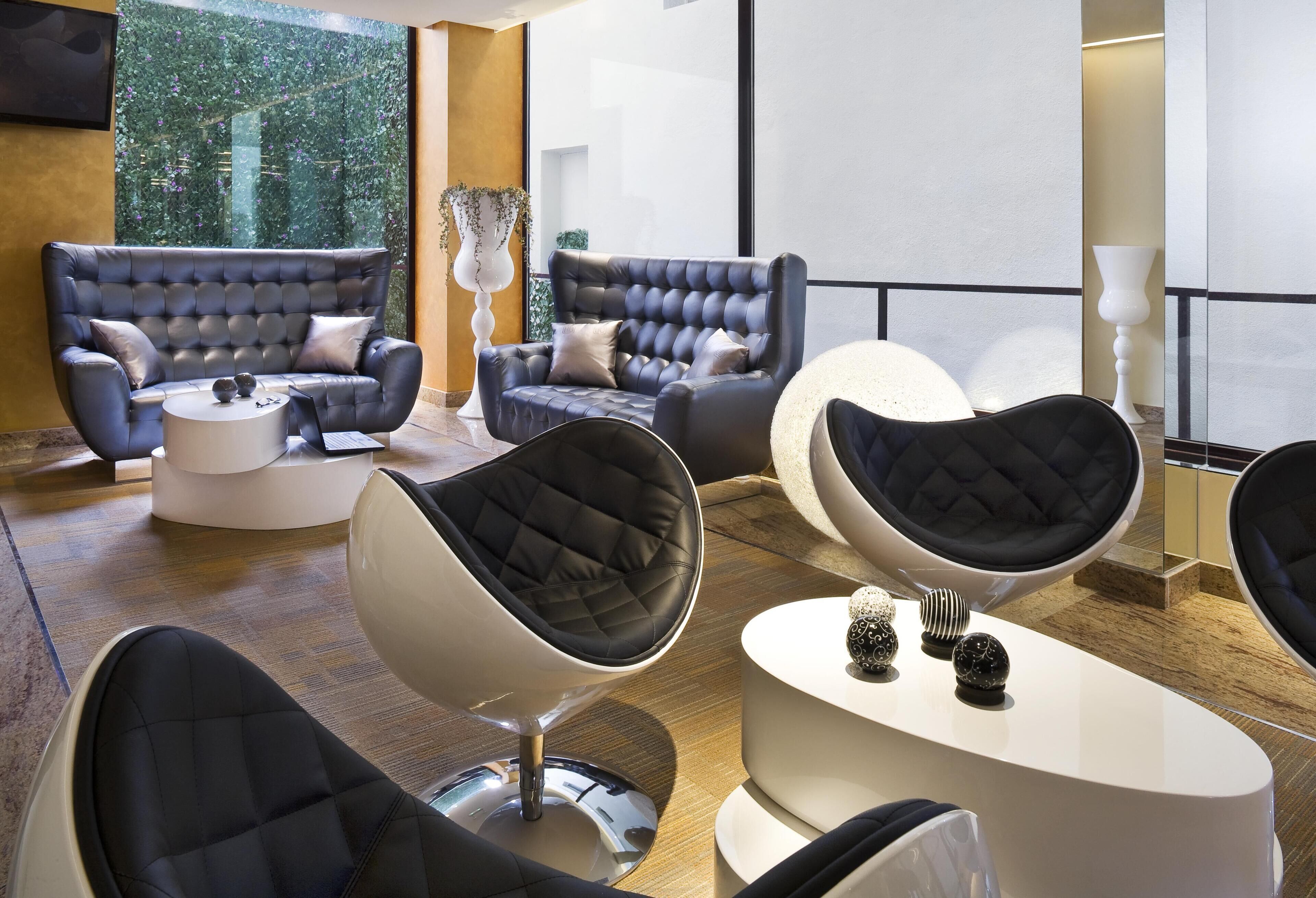 A modern lounge area with leather sofas, a round coffee table, and a unique egg chair.