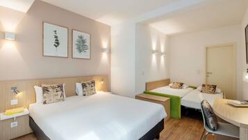 Habitación de hotel con dos camas, un escritorio y una silla.