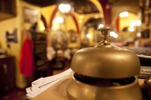 Gros plan d’une cloche en laiton posée sur une table, avec une serviette blanche en dessous.