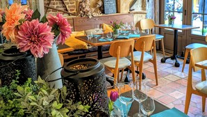 A rustic interior with exposed wooden beams, brick walls, and a dining area with wooden chairs and tables. - Hôtel Entre Terre et Mer (Honfleur)