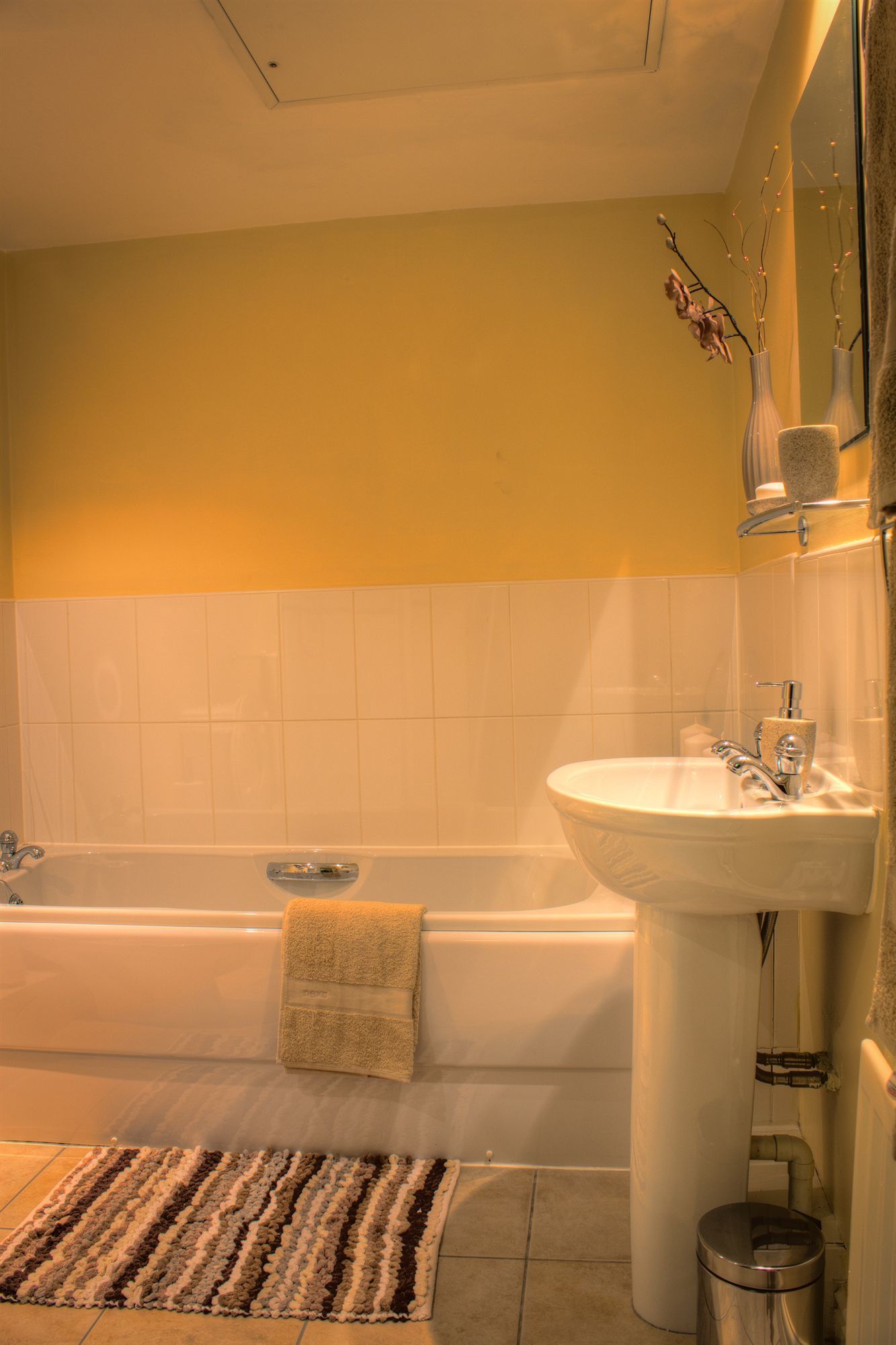 A bathroom with a bathtub, a sink, and a mirror.