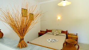 A bedroom with a bed, bedside tables, a nightstand, a lamp, and a vase. - Golden Apartments (Agios Nikolaos)