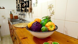 A kitchen counter with a bowl of fruits and a bottle of olive oil. - Golden Apartments (Agios Nikolaos)