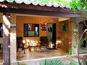 A brick building with a sign indicating 'EXU' and a door leading to an interior space. - Pousada Jardim dos Orixás (Aracati)