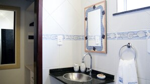 A bathroom with a sink, mirror, and towel rack. - Pousada Jardim dos Orixás (Aracati)