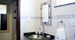 A bathroom with a sink, mirror, and towel rack. - Pousada Jardim dos Orixás (Aracati)