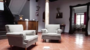 A spacious living room with two grey armchairs and a wooden coffee table. - Hotel La Ciudad (Ronda)