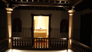 A staircase with a balustrade leading to a room with a bed and a window. - Hotel La Ciudad (Ronda)