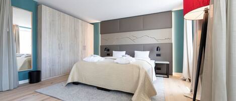 Un dormitorio moderno con una cama grande, una mesita de noche, una lámpara de pared y vistas al exterior.