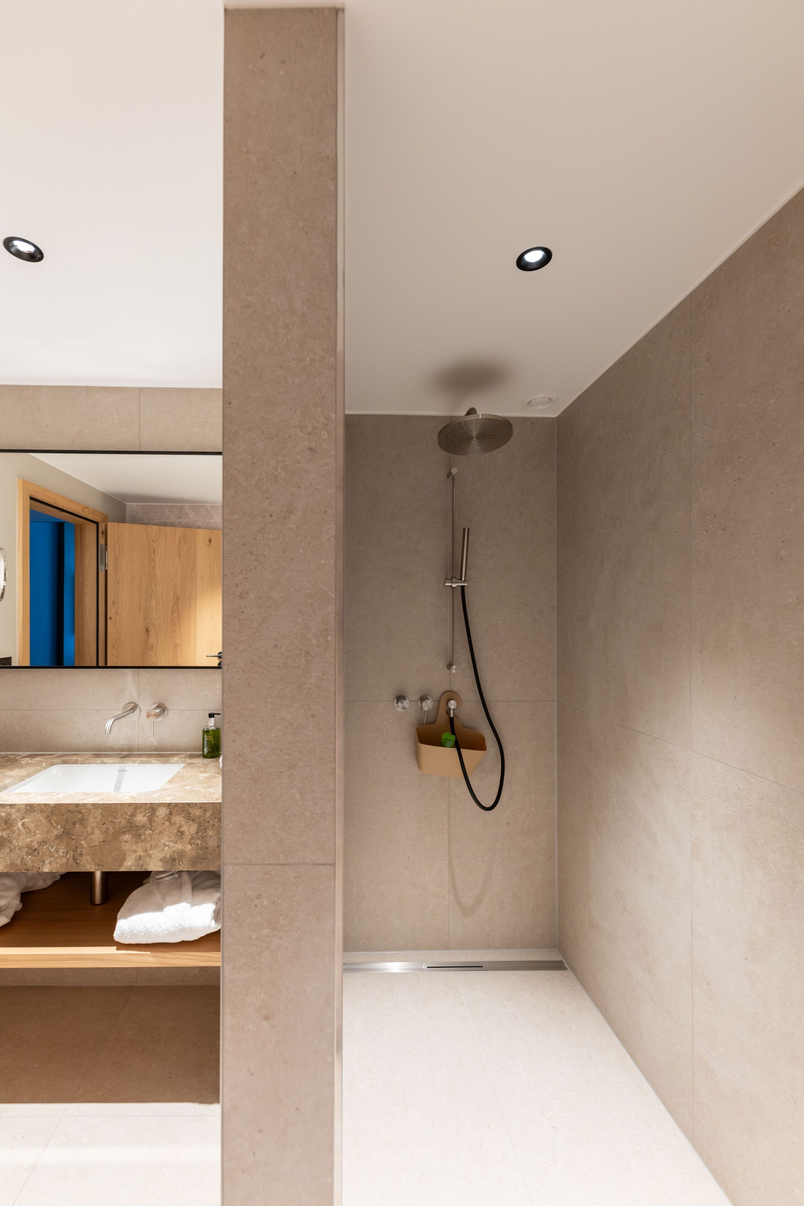 Une salle de bain moderne avec une douche, un lavabo et un miroir.
