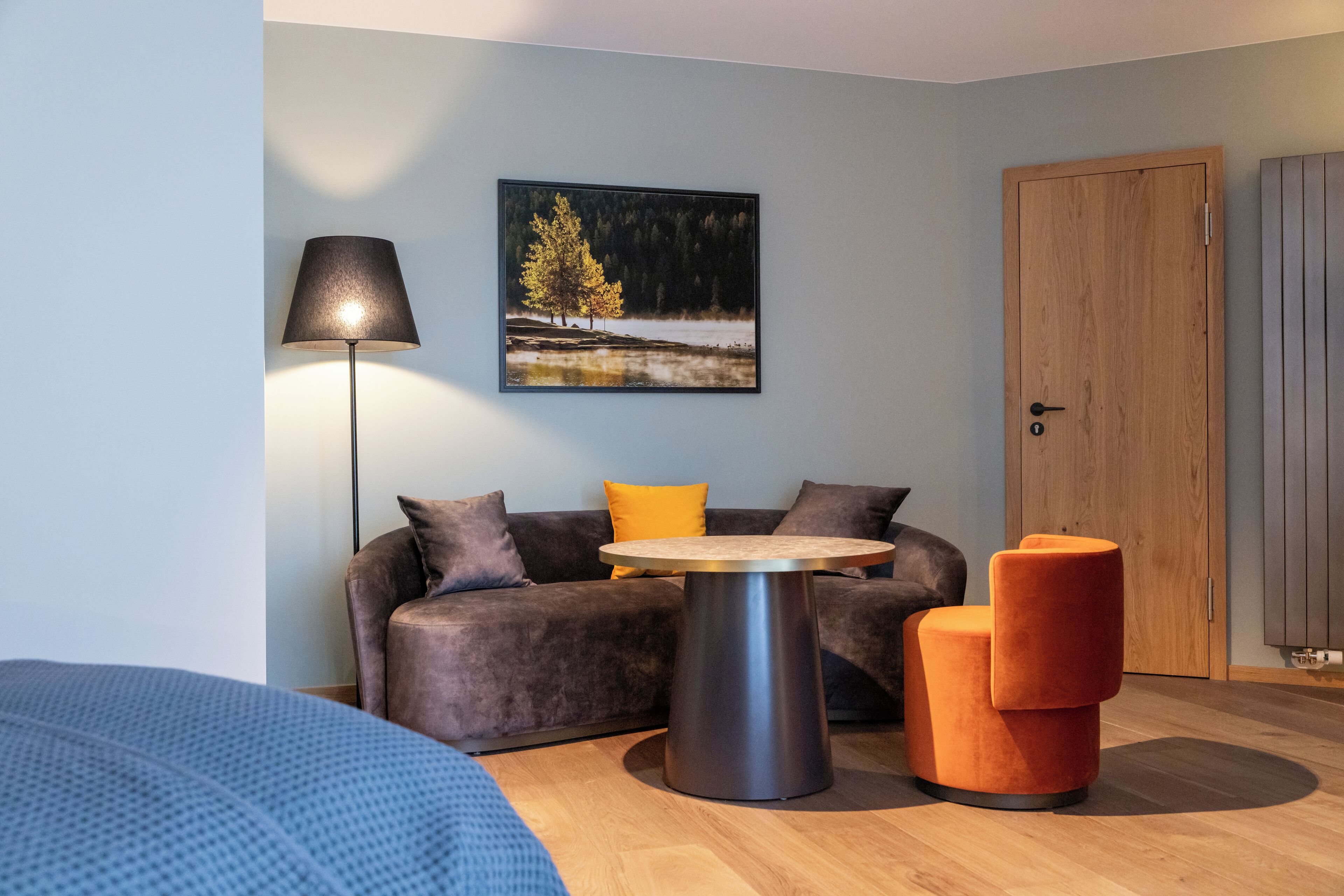 Una habitación moderna con sofá, una mesa redonda y una lámpara.
