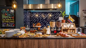 A breakfast buffet with various food items and a chalkboard sign with greetings. - 84 DC Bogotá By OxoHotel (Bogotá)