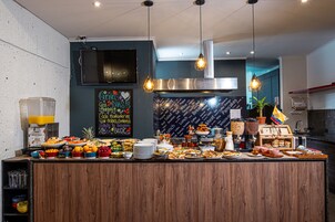 Zona de bufé con diferentes opciones de comida y un menú en una pizarra.
