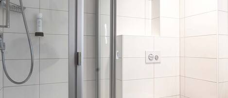 A modern bathroom with a glass-enclosed shower, a toilet, and a sink.