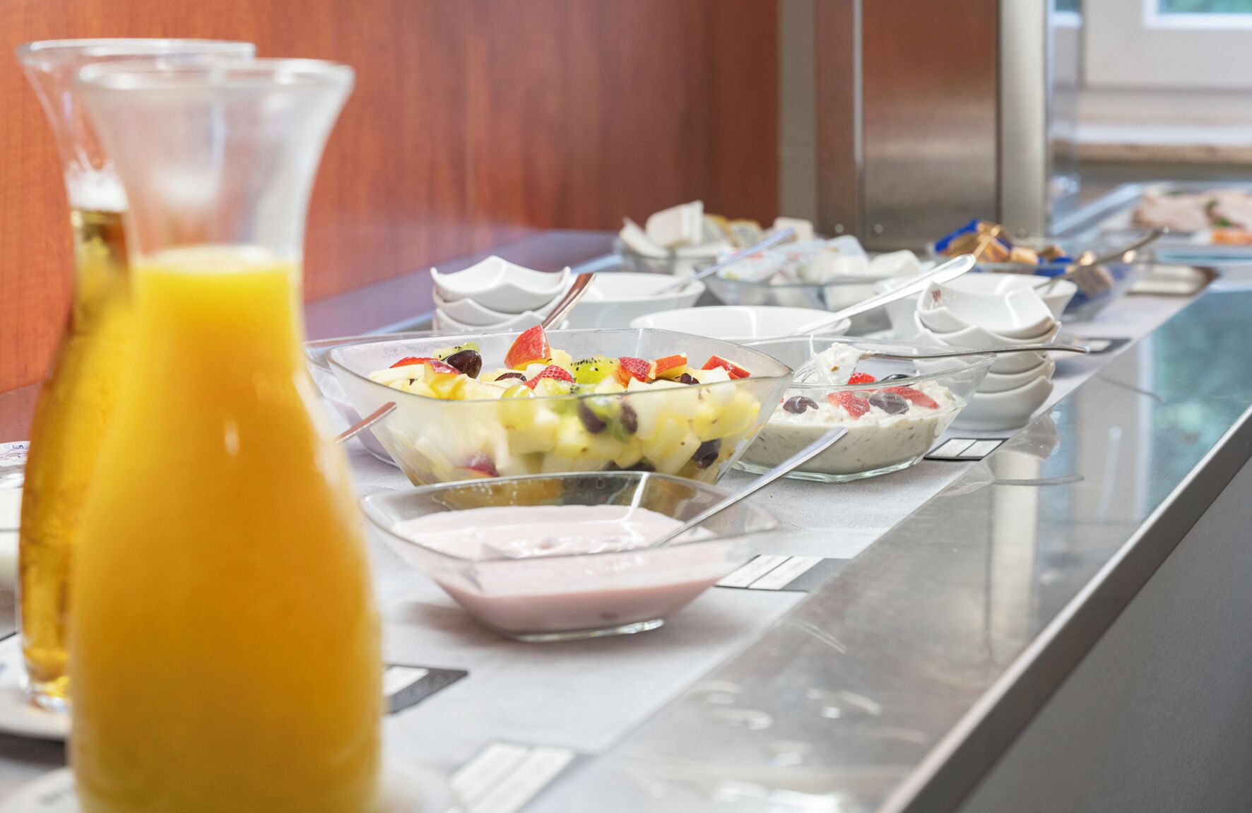 A buffet with various food options including fruit salads, yogurt, and other dishes.