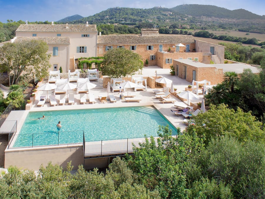 Een buitenzwembad, parasols bij het zwembad en ligstoelen