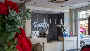 A hotel reception desk with a sign reading "Sevilla Hotel" and a modern interior design. - Hotel Sevilla (Ronda)