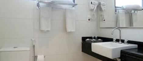 Un baño moderno con inodoro, lavabo y perchero para toallas.