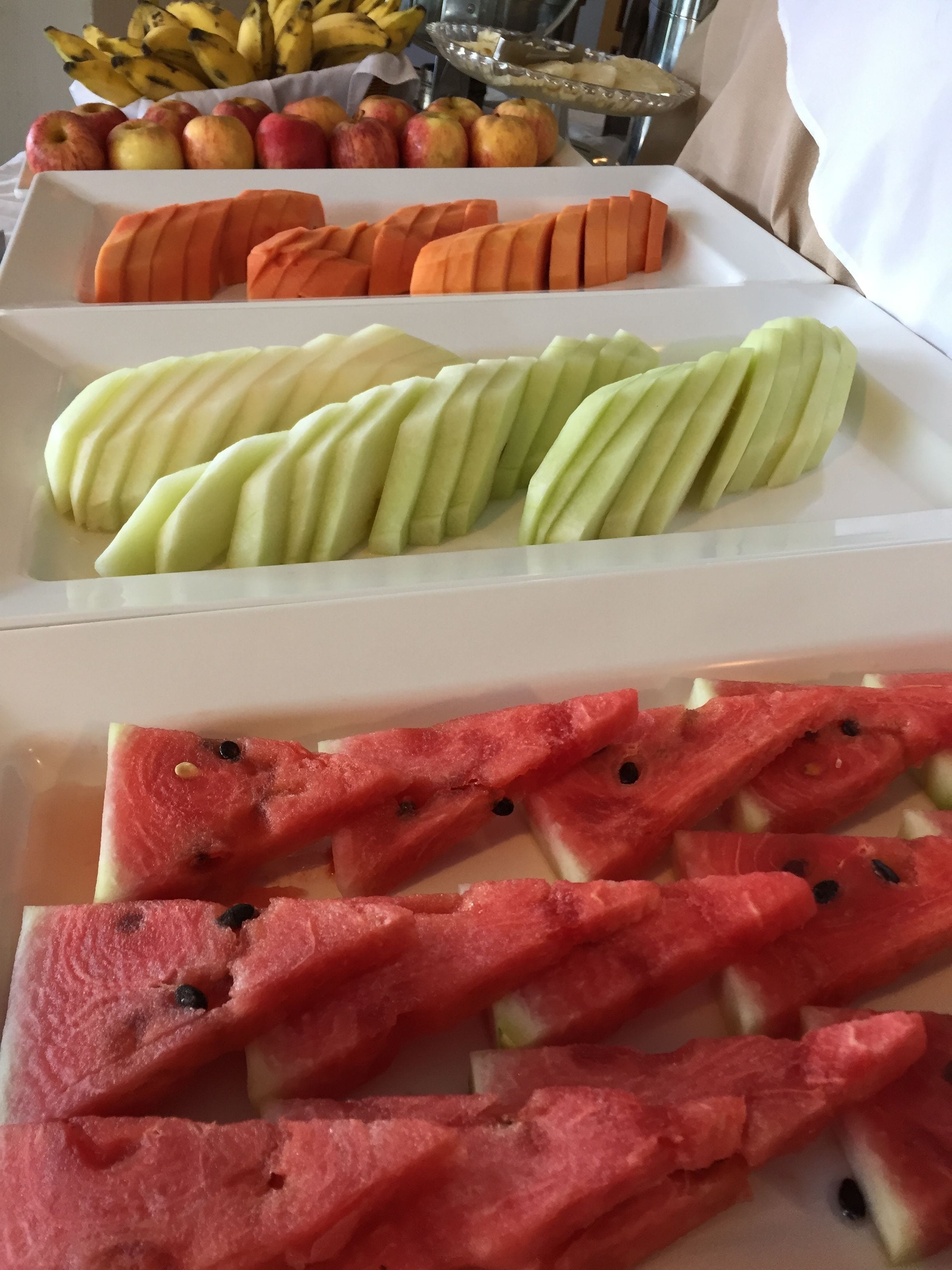 A fruit display with sliced apples, oranges, and watermelon.